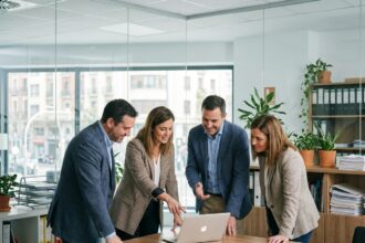 Groupe de quatre professionnels en réunion de travail
