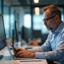 Homme d'âge moyen travaillant au bureau avec ordinateur et smartphone