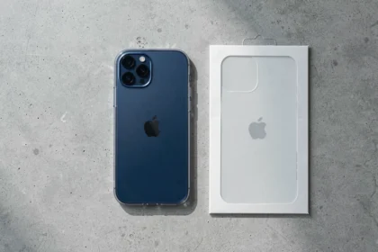 iPhone 12 avec coque transparente et protection en verre trempé posés sur une surface en béton gris