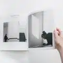 person reading book on white surface