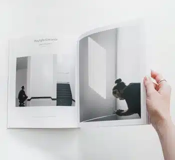 person reading book on white surface