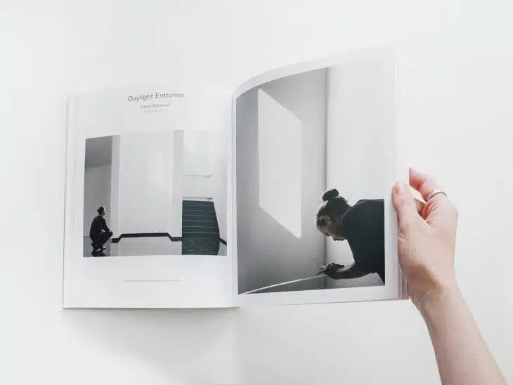 person reading book on white surface