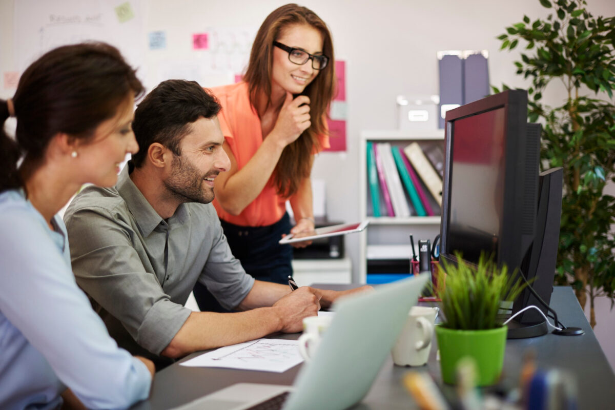 trois personnes travaillent dans une agence web et sont sur un projet